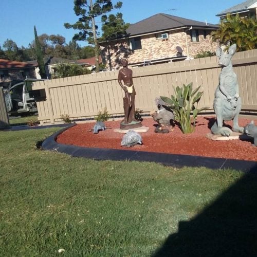 Continuous concrete garden edging kerb with statues and decorative gravel