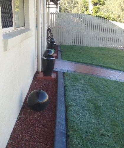 Continuous concrete garden edging kerb parallel to front of house