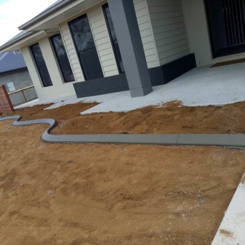 Continuous concrete garden edging kerb around outside on new house