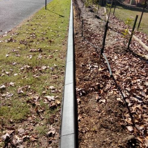 Straight line of continuous concrete garden edging kerb