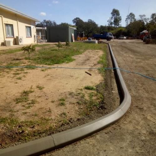 Continuous concrete driveway edging kerb on rural property